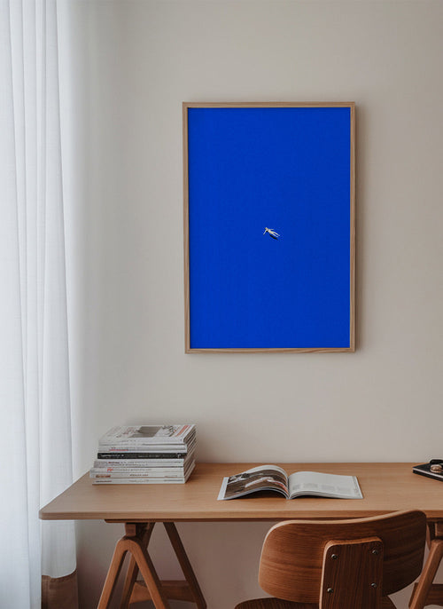 Minimalistisk tavla med svävande figur mot blå himmel