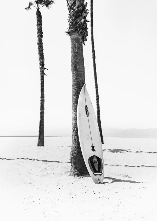 Sportkonst: surfbräda på stranden svartvit