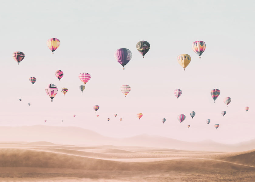 Landskap med luftballonger över sanddyner