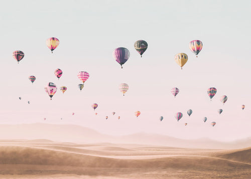 Landskap med luftballonger över sanddyner