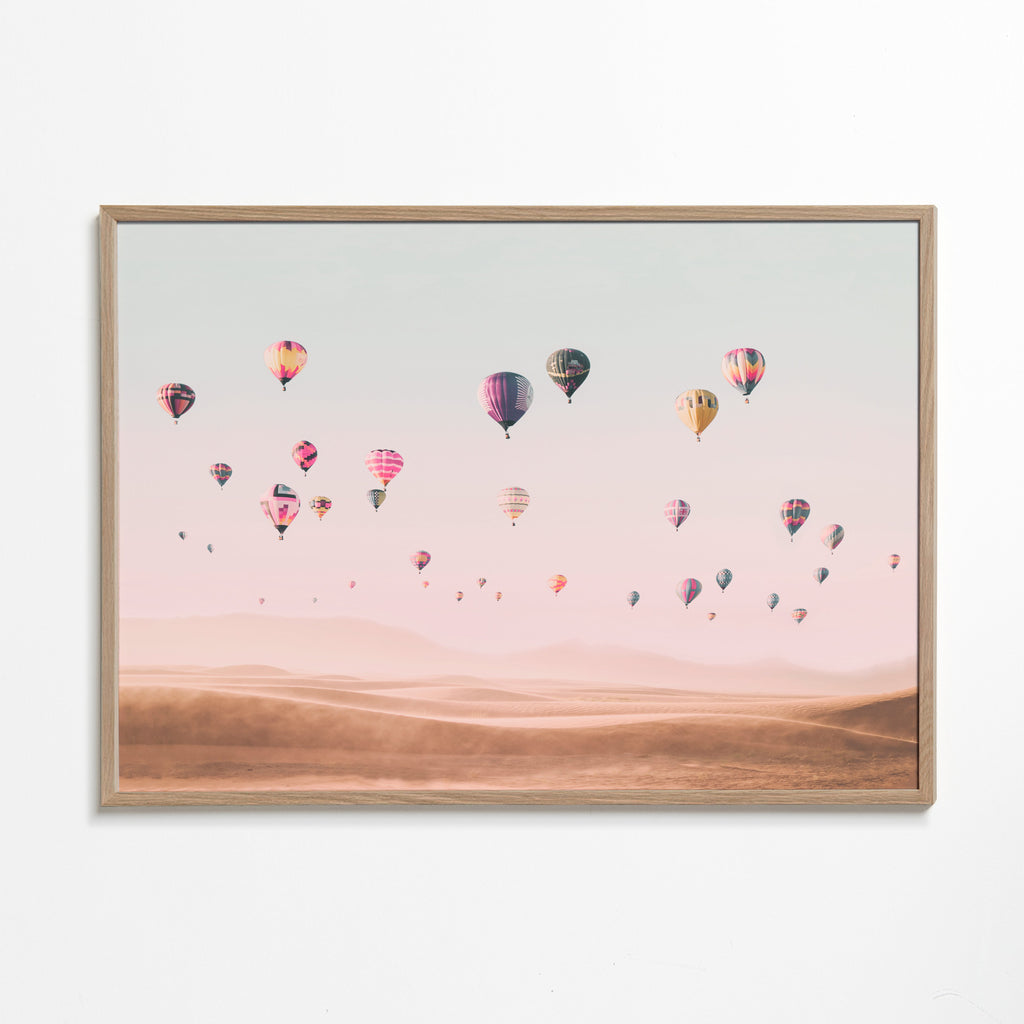 Landskap med luftballonger över sanddyner