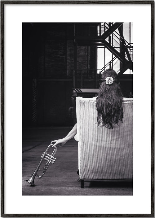 Fotografi av sittande musiker sett bakifrån med trumpet