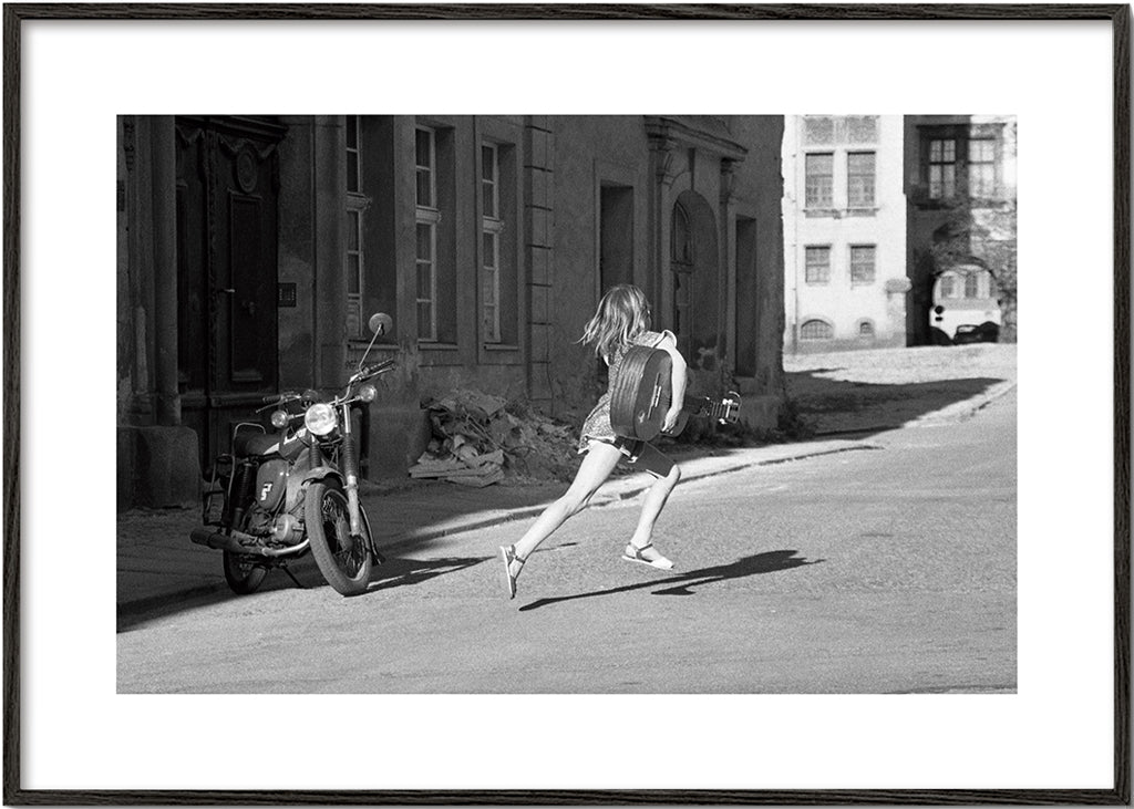 Svartvit bild: flicka springer på gatan