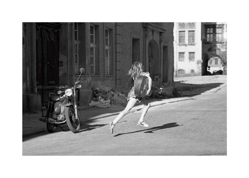 Svartvit bild: flicka springer på gatan
