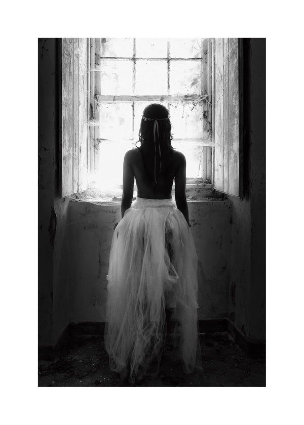Fotografi figur sedd bakifrån vid fönster
