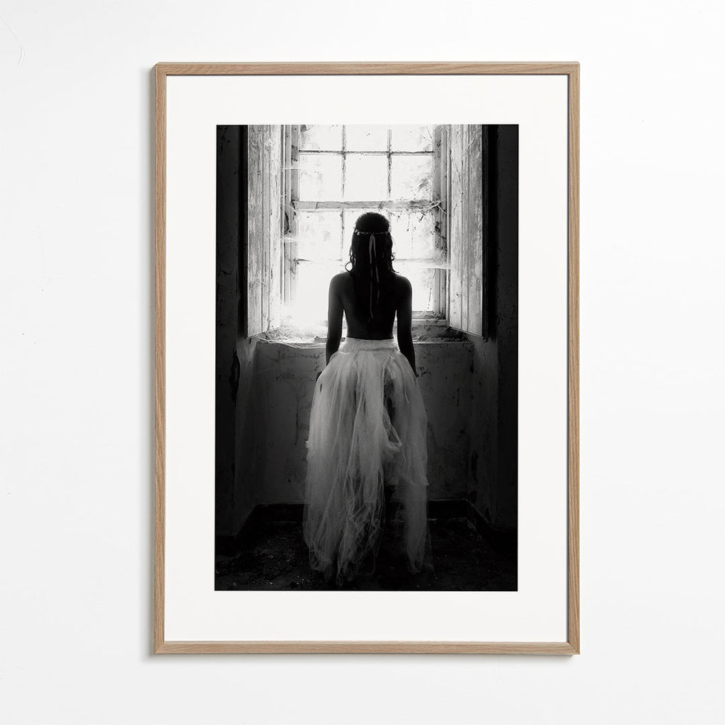 Fotografi figur sedd bakifrån vid fönster