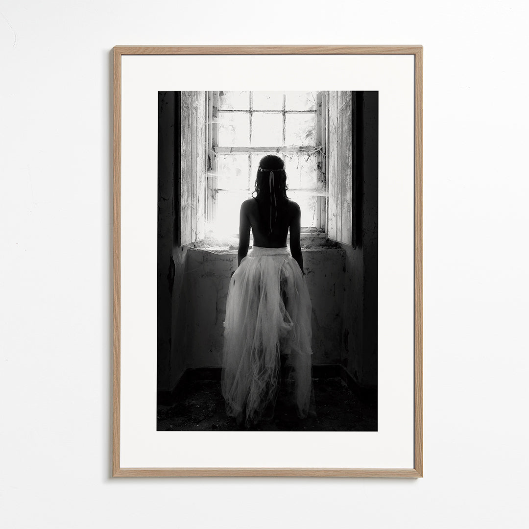 Fotografi figur sedd bakifrån vid fönster