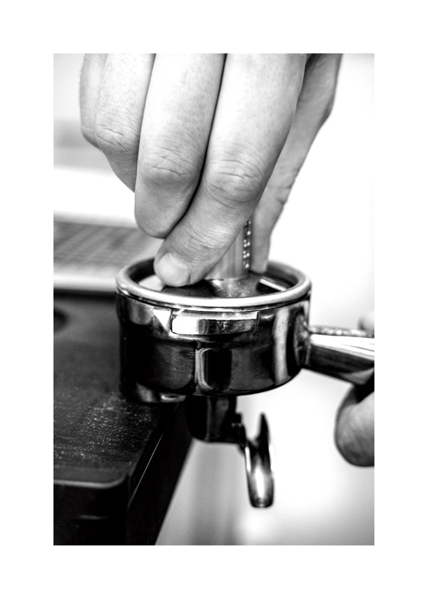 Kökskonst: händer som tampar espresso på nära håll