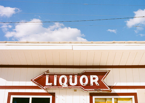 Vintagefoto skylt 'LIQUOR' mot blå himmel