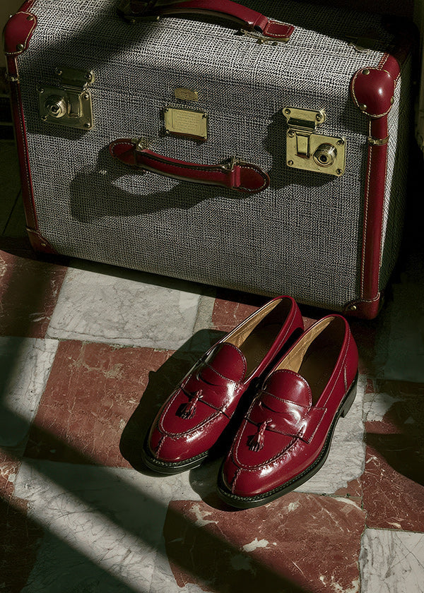 Resefotografi med vintage-resväska och röda loafers