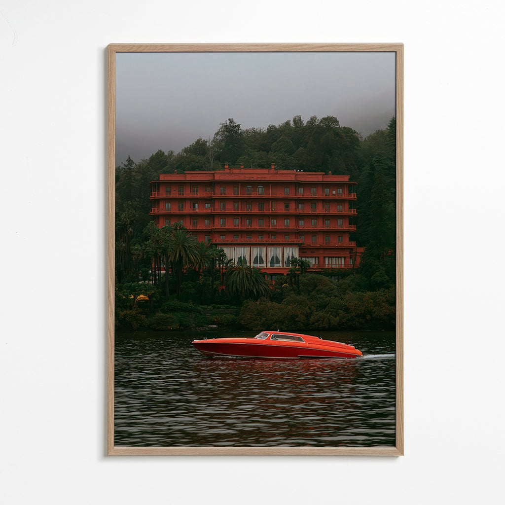 Landskapskonst med rött hotell och snabb båt